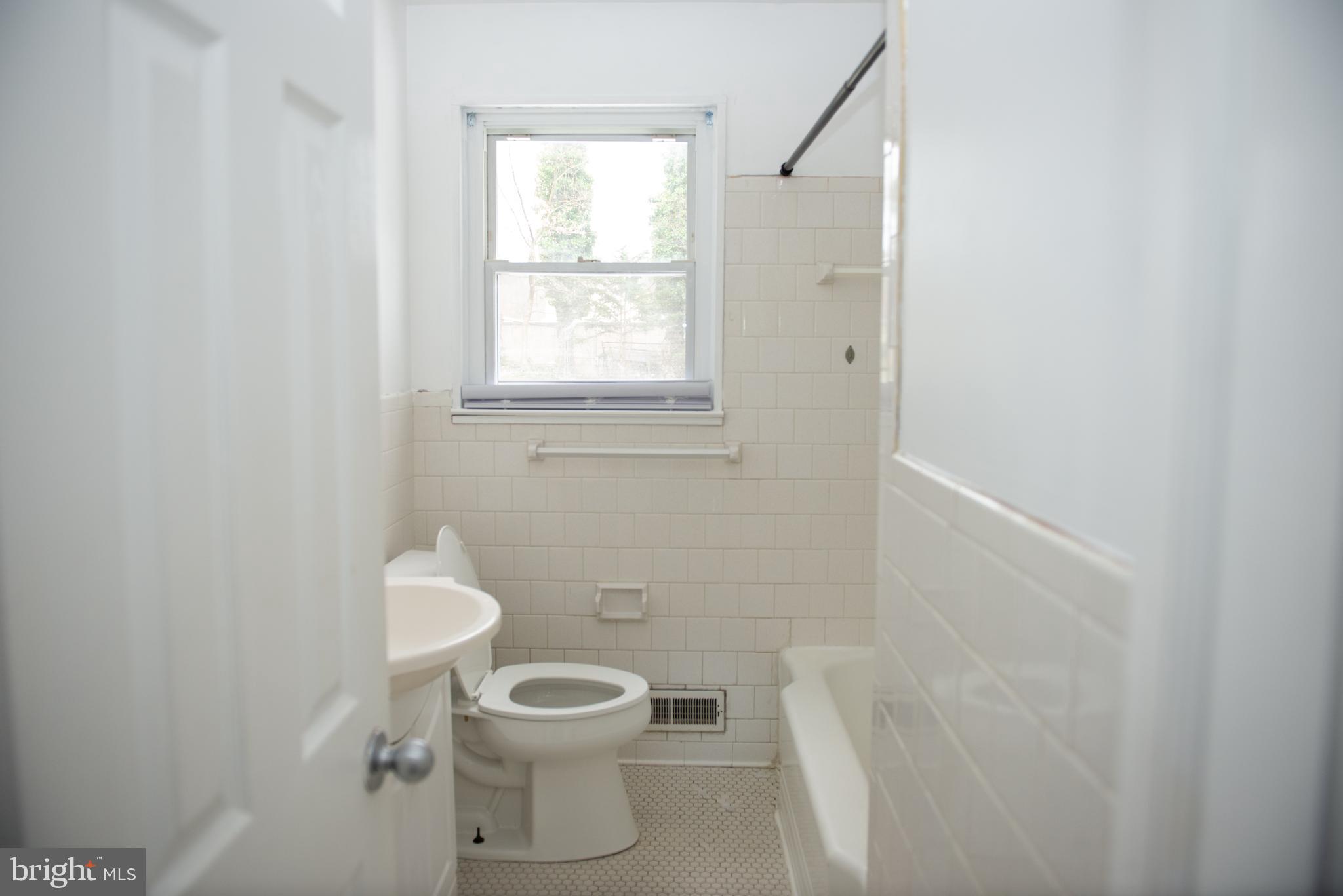 521 Warren Road, Unit 2 Cockeysville, MD 21030 - Photo 14 of 19 a white toilet sitting next to a bathroom sink and vanity