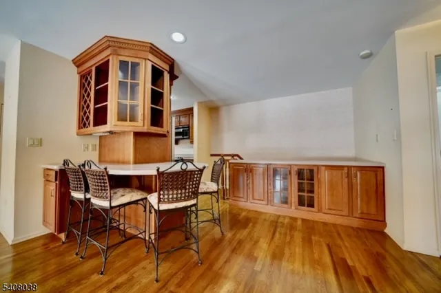 a kitchen with stainless steel appliances granite countertop a refrigerator a stove and a sink with wooden floor