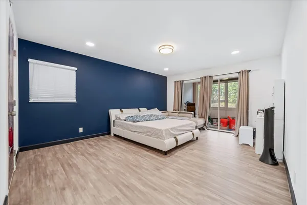 a bedroom with a bed and wooden floor