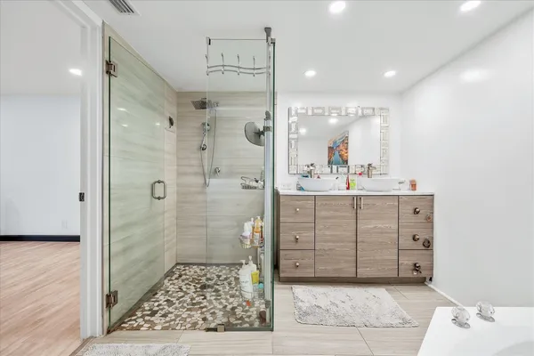 a bathroom with a sink shower and a mirror