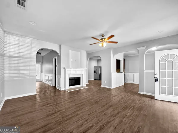 a view of empty room with wooden floor and fireplace