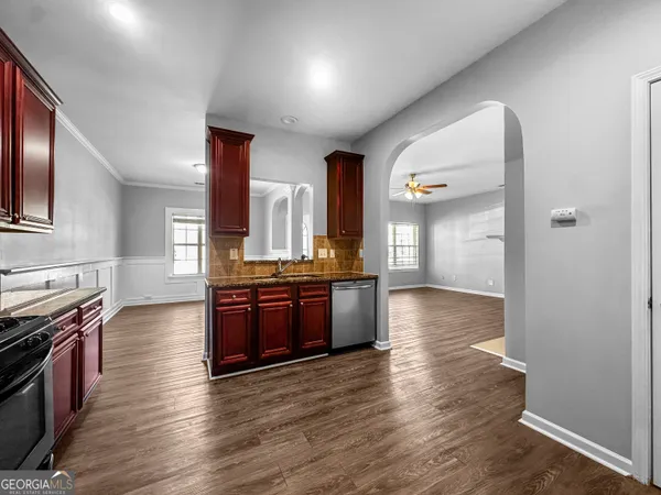 a large kitchen with stainless steel appliances granite countertop a large counter top and wooden floor