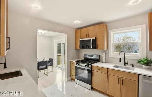 a kitchen with stainless steel appliances granite countertop a stove a sink and a microwave