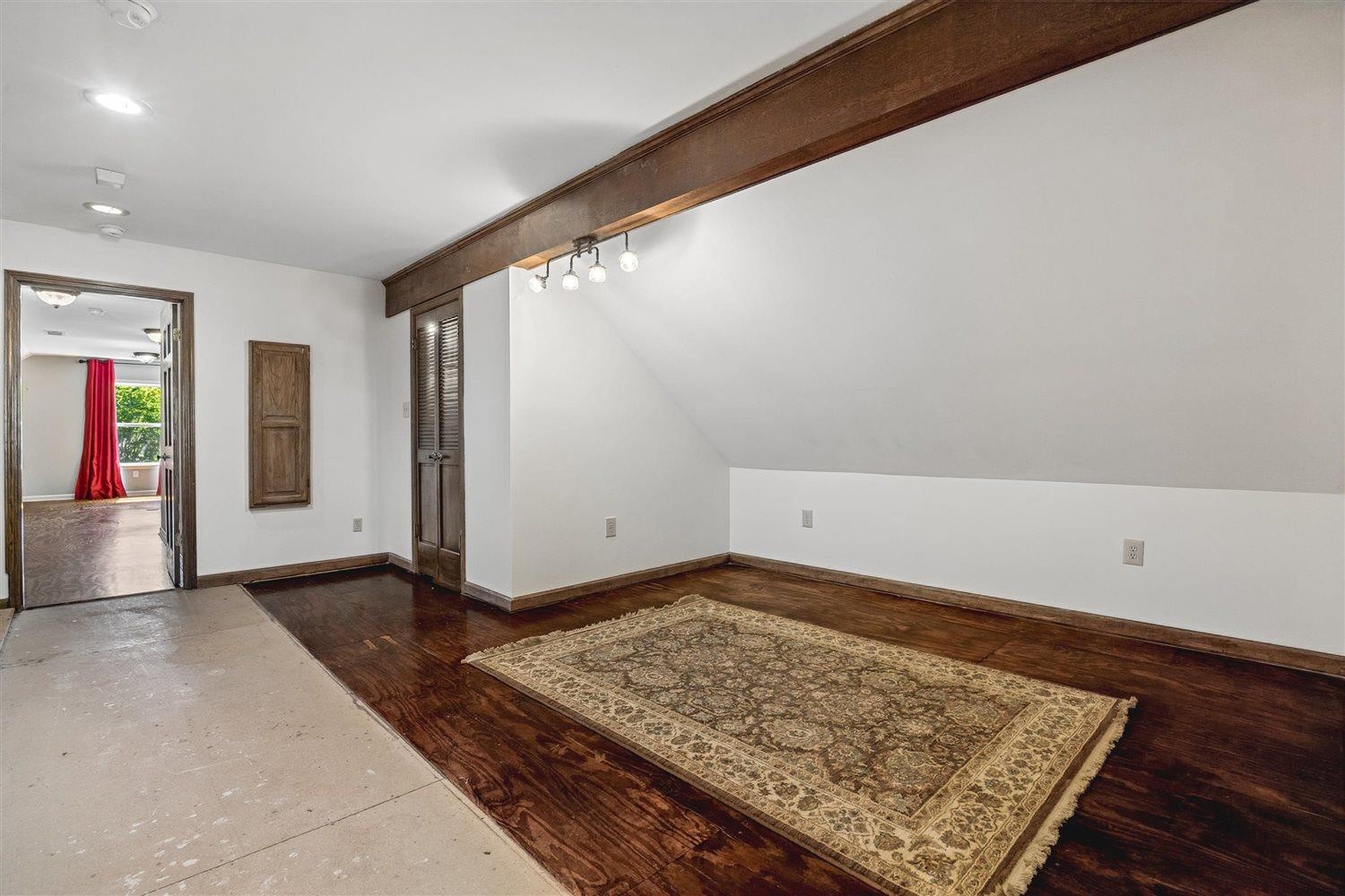 8970 Farmoor Road Germantown, TN 38139 - Photo 21 of 35 Room featuring wood-finish flooring, a prominent exposed wood beam, and a sloped ceiling