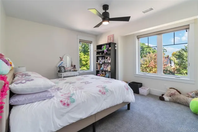 a bedroom with a bed a baby bed and a window