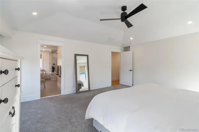 a large white kitchen with a sink and a large mirror