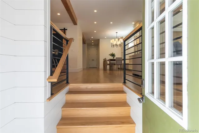 a view of staircase with lots of frames on wall and a potted plant