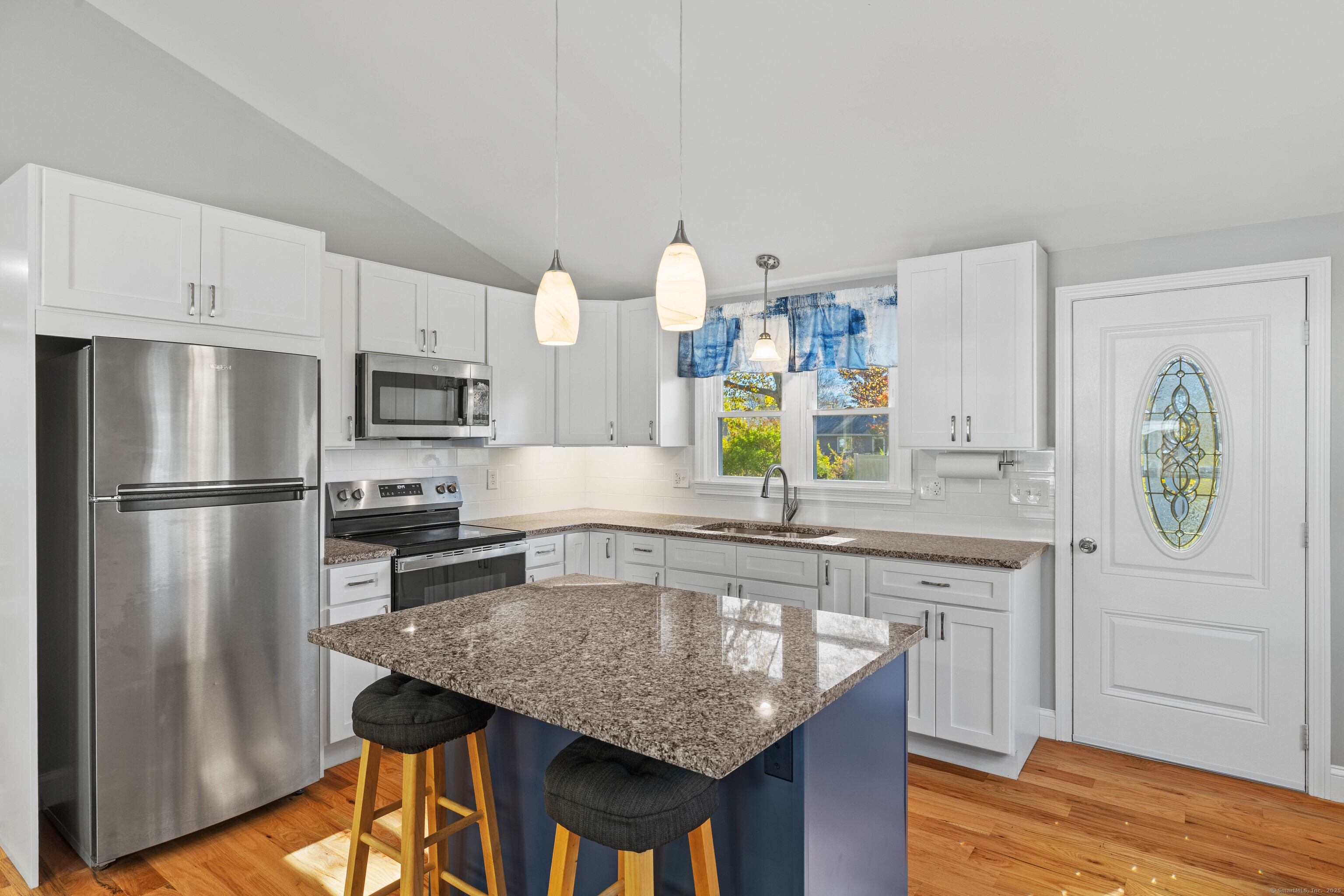 48 Billow Road East Lyme, CT 06357 - Photo 14 of 40 a kitchen with kitchen island granite countertop a sink a stove a refrigerator cabinets and wooden floor