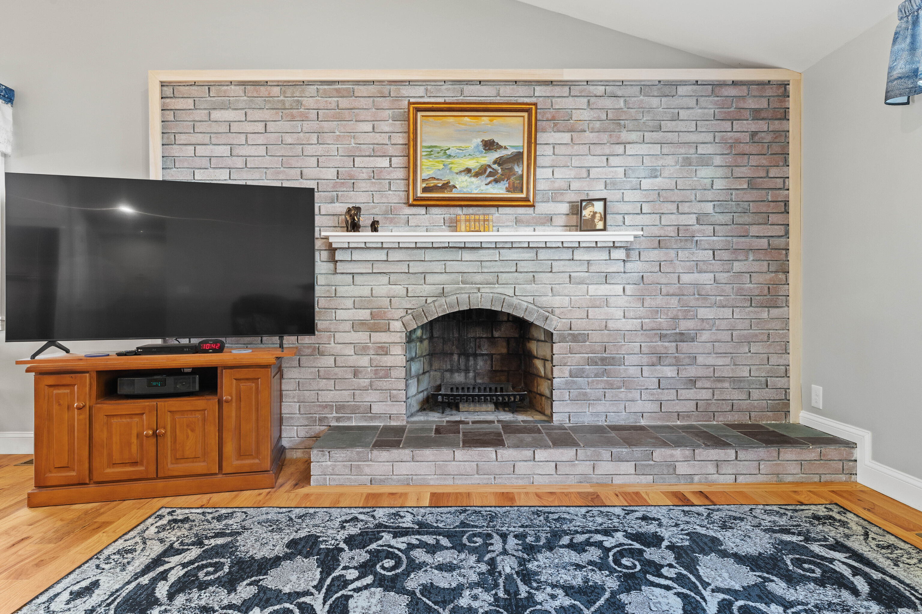 48 Billow Road East Lyme, CT 06357 - Photo 9 of 40 a living room with a flat screen tv and a fireplace