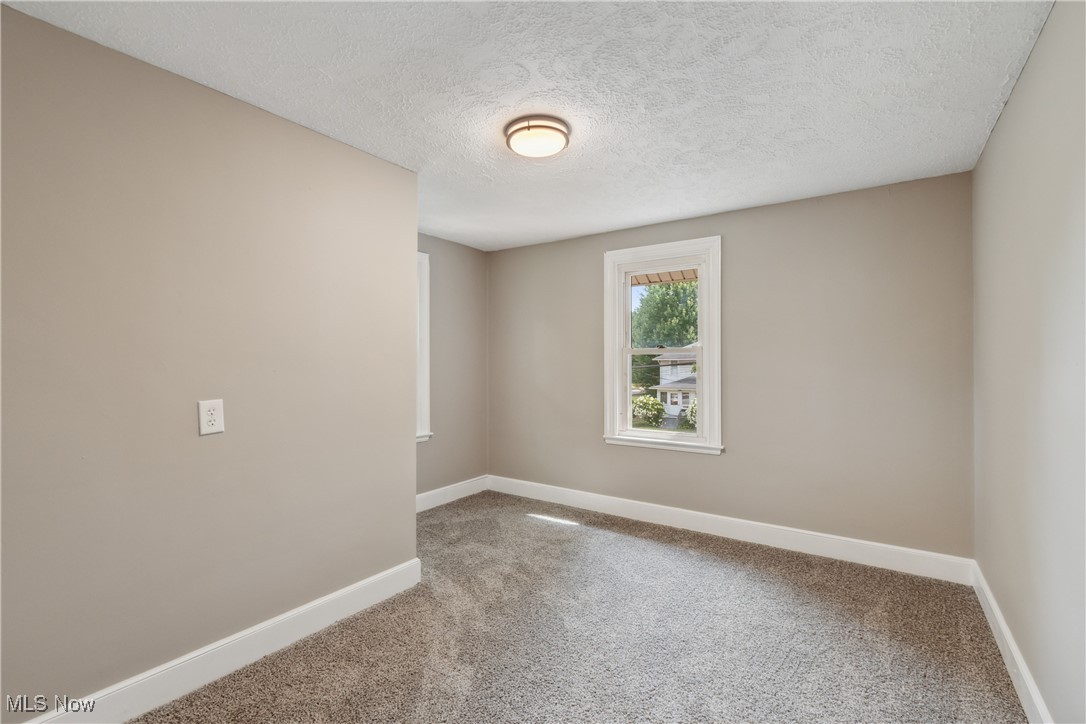 451 West Waterloo Road Akron, OH 44314 - Photo 19 of 27 Carpeted spare room featuring a textured ceiling