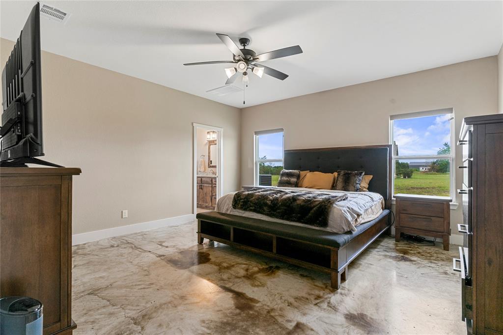 139 Kriston Lane Springtown, TX 76082 - Photo 20 of 39 Spacious room featuring polished concrete flooring, two large windows, and a ceiling fan with integrated lighting