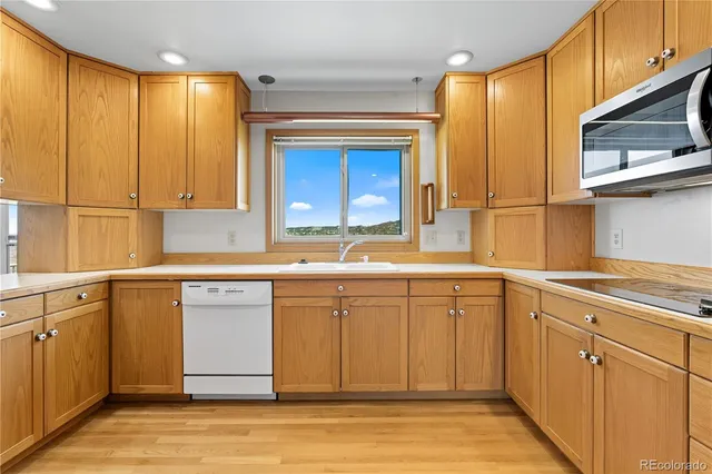 a kitchen with granite countertop cabinets stainless steel appliances a sink and a window