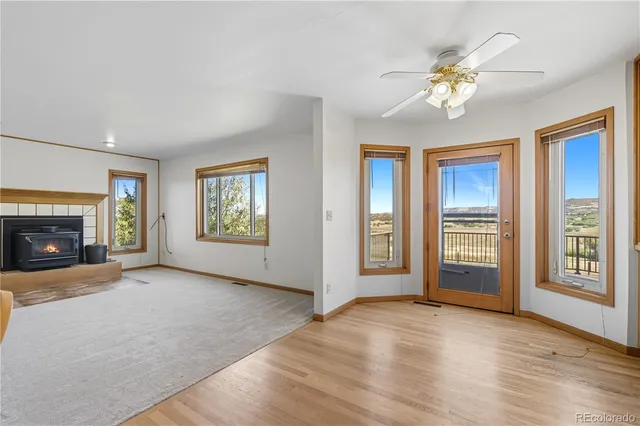 a view of an empty room with a window and fireplace