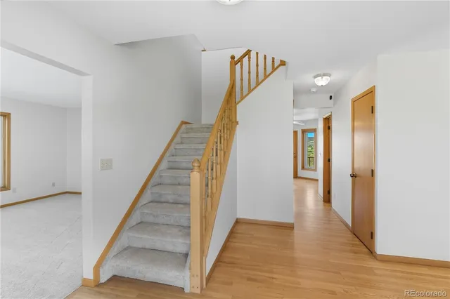 a view of a hallway with wooden floor and staircase