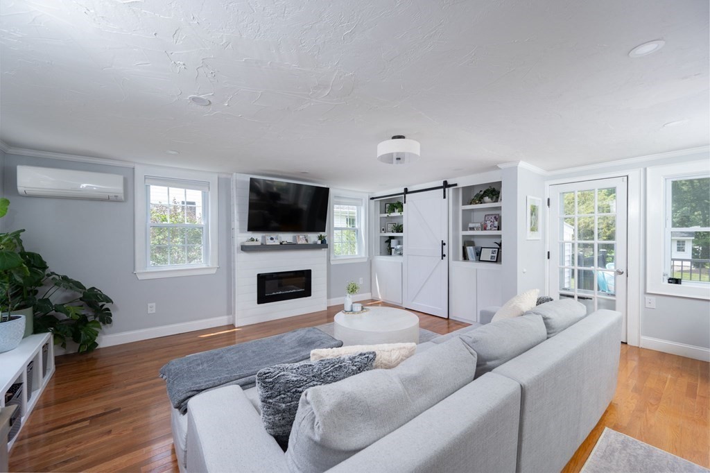 1054 Brook Road Milton, MA 02186 - Photo 8 of 23 a living room with furniture flat screen tv and a fireplace