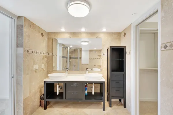 a bedroom with a balcony a bed and a flat tv screen next to a window