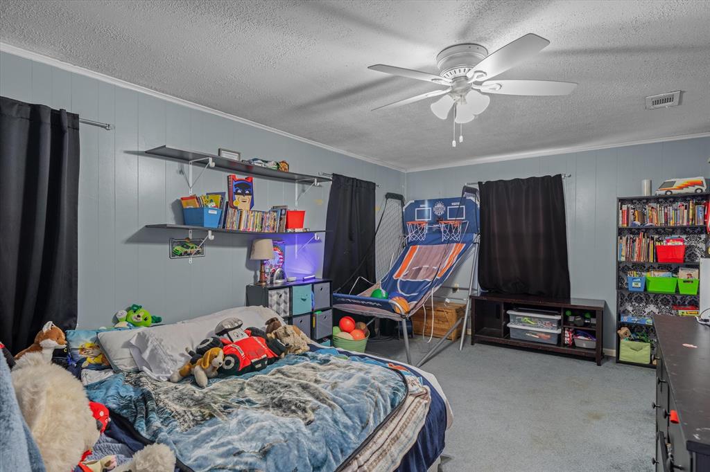 503 South Houston Street Edgewood, TX 75117 - Photo 17 of 31 a bedroom with bed and a chandelier