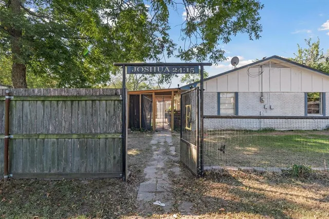 a view of a small house with a small yard and a large tree