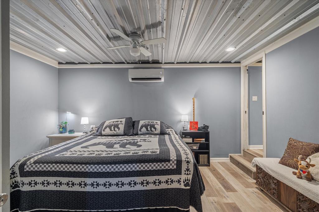 503 South Houston Street Edgewood, TX 75117 - Photo 7 of 31 a bedroom with a bed and wooden floor