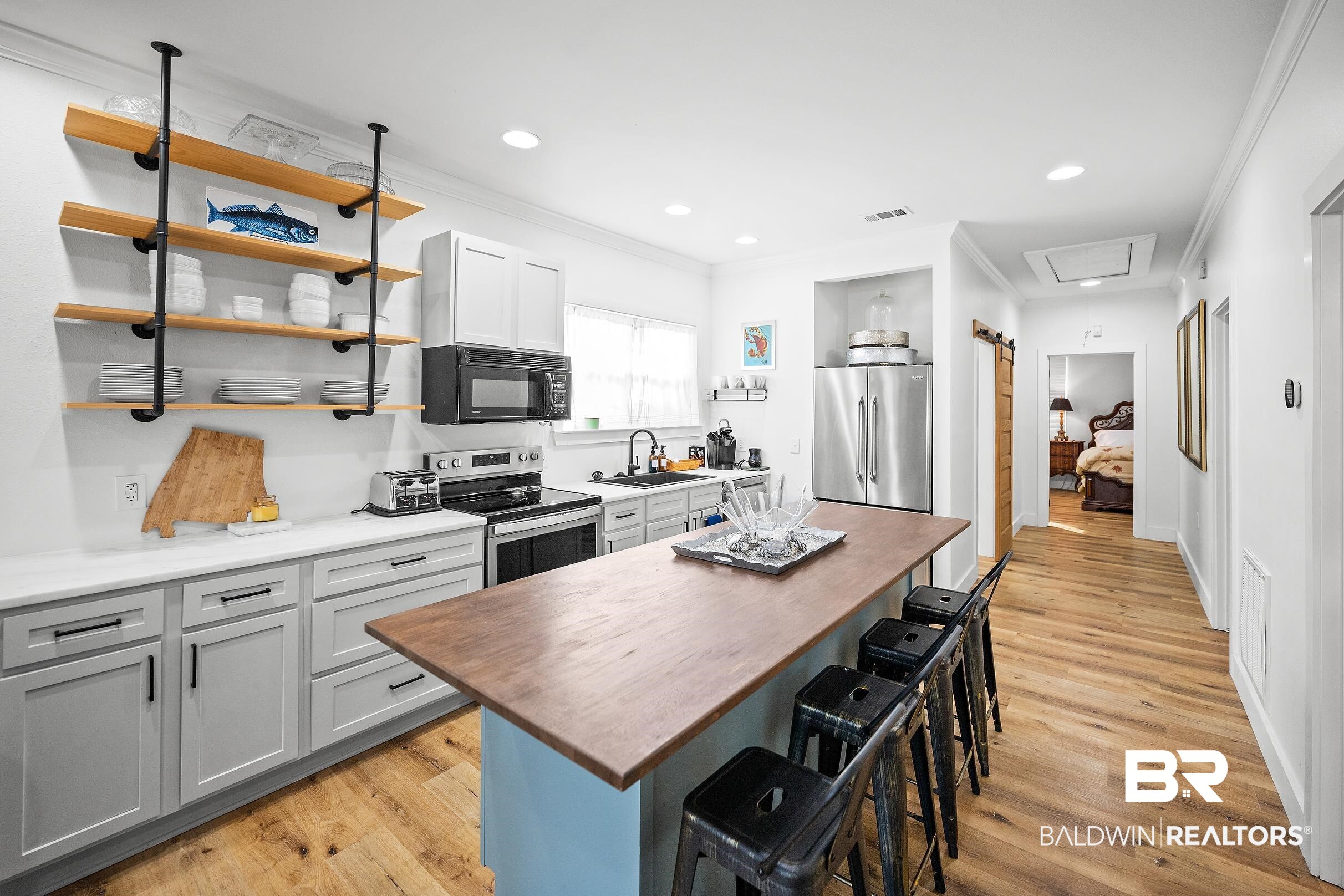 8490 Bay View Drive Foley, AL 36535 - Photo 52 of 67 Kitchen featuring ornamental molding, light wood-style floors, appliances with stainless steel finishes, a breakfast bar, and butcher block counters