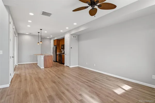 a view of a livingroom with a ceiling fan wooden floor and window