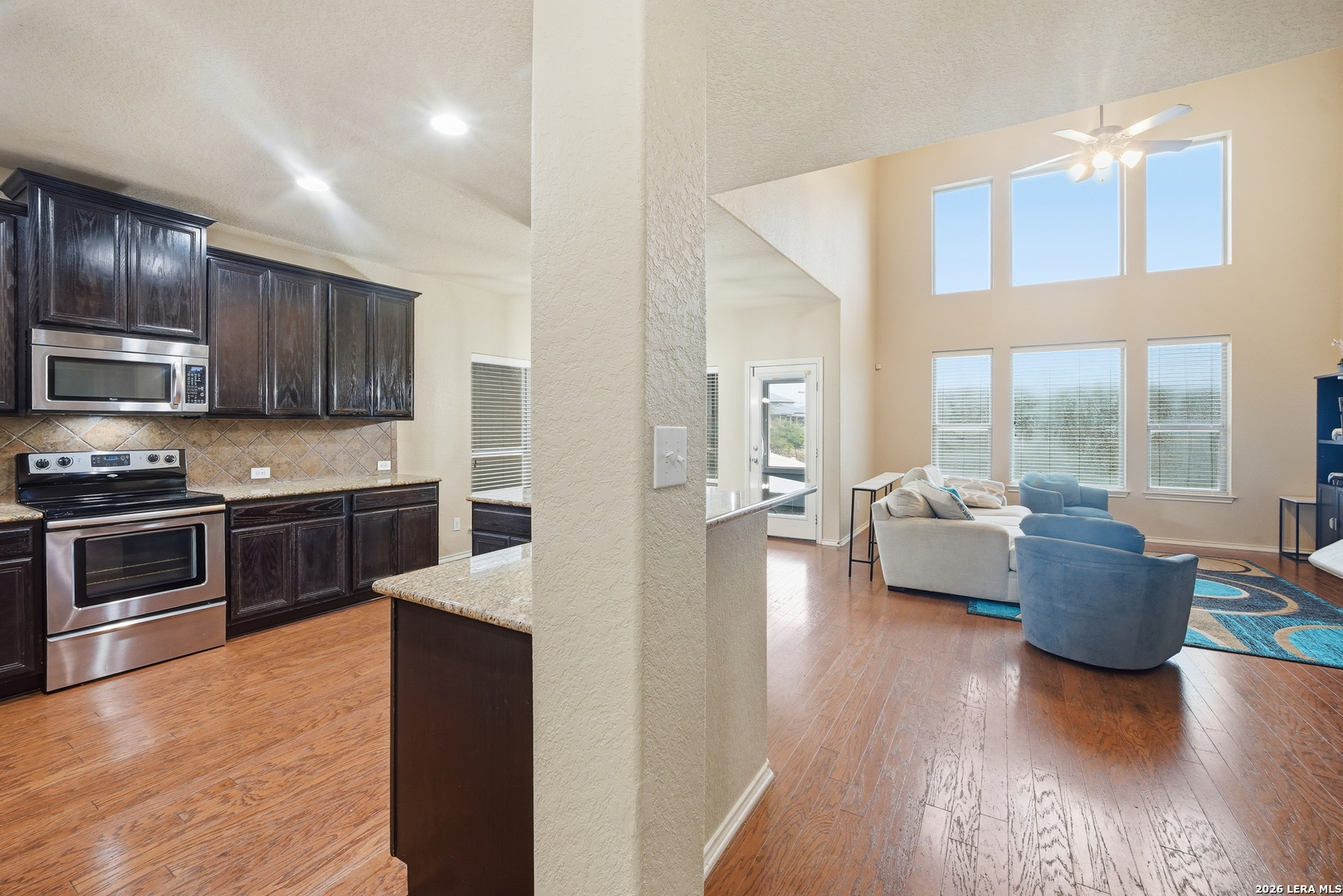 313 Brook Shadow Cibolo, TX 78108 - Photo 6 of 29 a kitchen with granite countertop wooden floors and stainless steel appliances