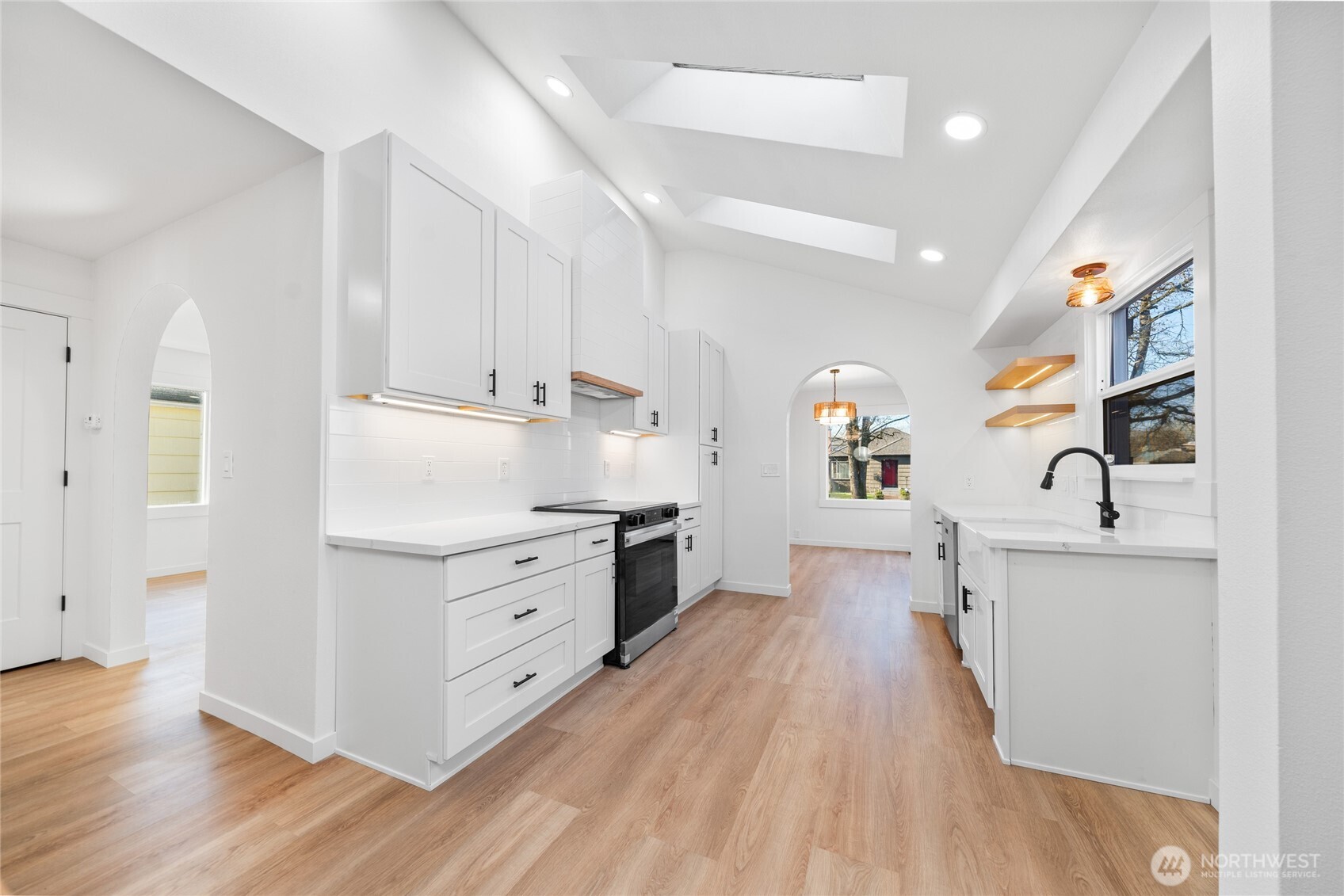 1308 19th Avenue Longview, WA 98632 - Photo 2 of 24 a kitchen with stainless steel appliances a stove top oven a sink a refrigerator white cabinets and wooden floor