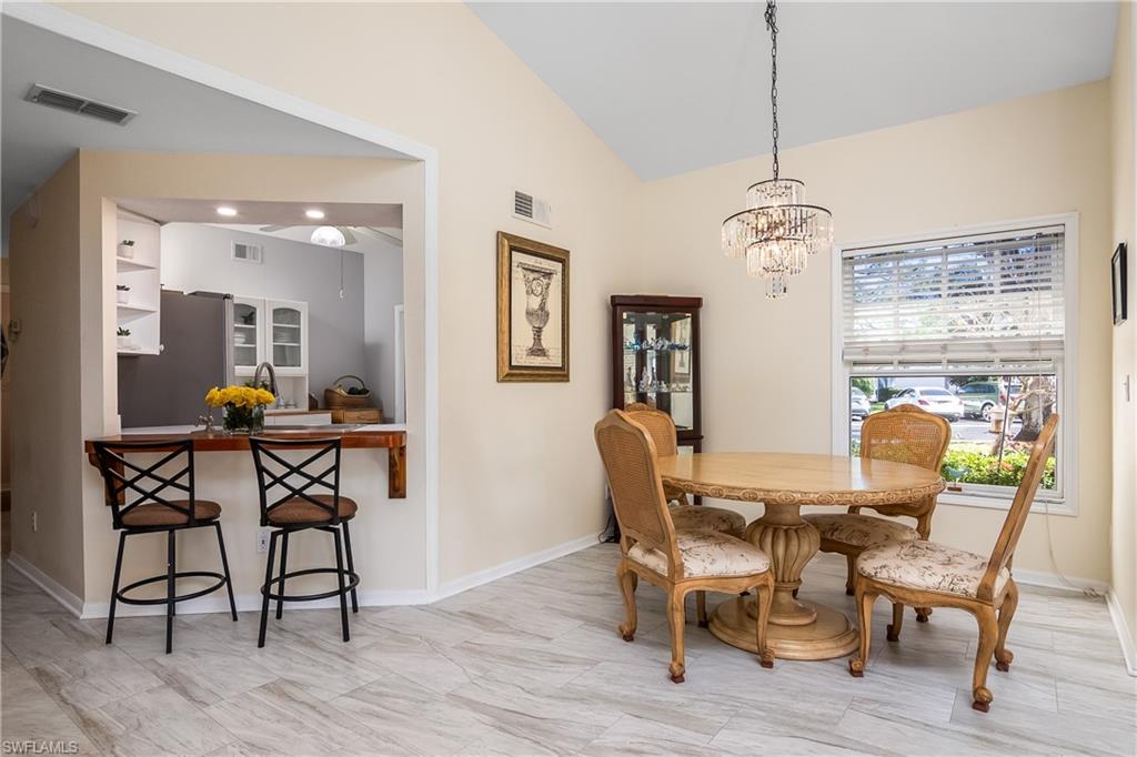 613 Windsor Square, Unit 101 Naples, FL 34104 - Photo 12 of 23 a view of a dining room with furniture window and wooden floor