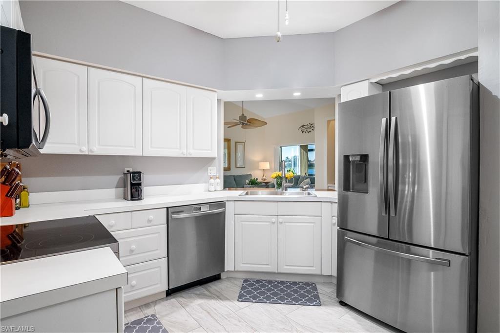 613 Windsor Square, Unit 101 Naples, FL 34104 - Photo 14 of 23 a kitchen with a refrigerator sink and cabinets