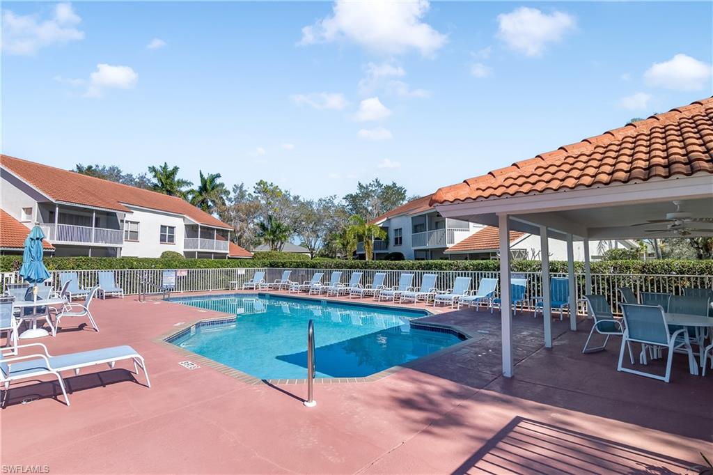 613 Windsor Square, Unit 101 Naples, FL 34104 - Photo 20 of 23 a patio with swimming pool table and chairs