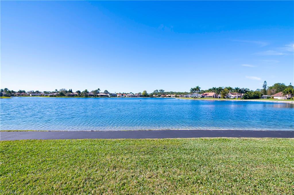 613 Windsor Square, Unit 101 Naples, FL 34104 - Photo 6 of 23 a view of a lake with houses in the back