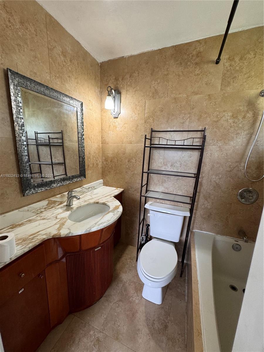 316 Southwest 2nd Terrace Hallandale Beach, FL 33009 - Photo 12 of 16 a bathroom with a granite countertop toilet sink and mirror