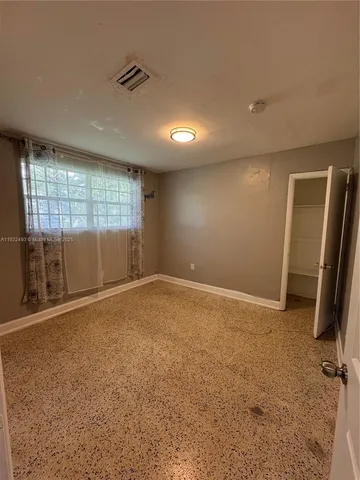 an empty room with a fireplace and windows