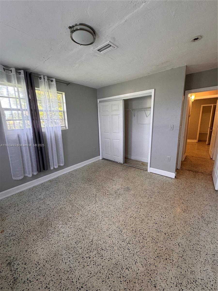316 Southwest 2nd Terrace Hallandale Beach, FL 33009 - Photo 10 of 16 a view of an empty room with wooden floor and windows