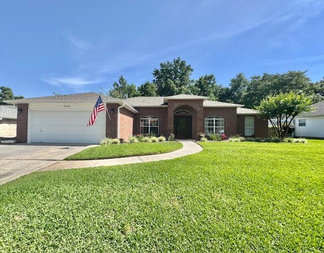 a view of a house with a yard and a garage