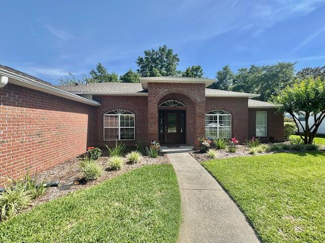 4258 Shadow Lane Niceville, FL 32578 - Photo 2 of 35 a front view of a house with garden