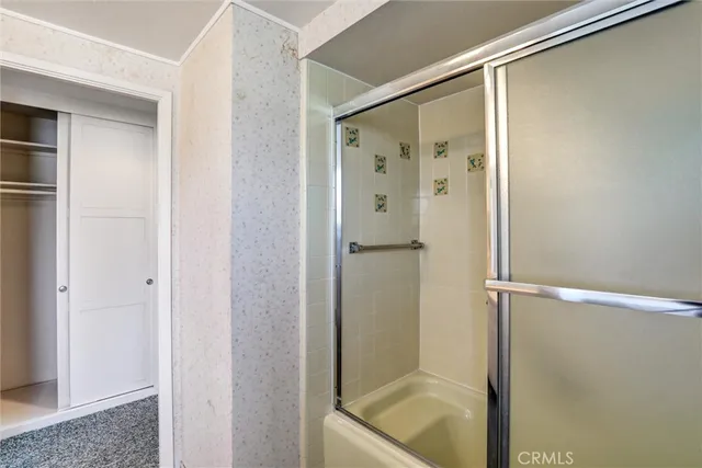 a view of a hallway with wooden floor and a bathroom