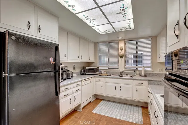 a kitchen with a sink appliances cabinets and a counter space