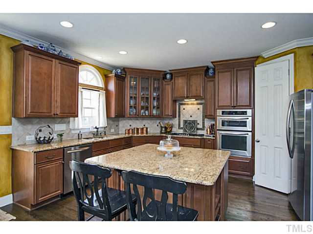10001 Hidden Vale Drive Raleigh, NC 27614 - Photo 13 of 24 a kitchen with a table chairs refrigerator and cabinets