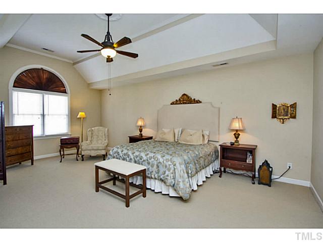 10001 Hidden Vale Drive Raleigh, NC 27614 - Photo 17 of 24 a bedroom with a bed and a chandelier