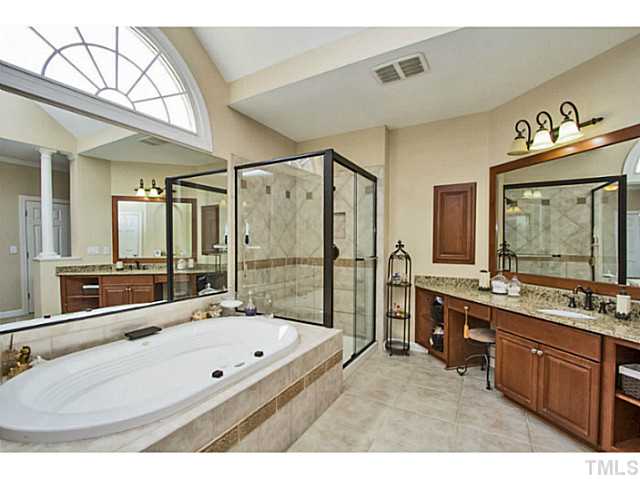 10001 Hidden Vale Drive Raleigh, NC 27614 - Photo 18 of 24 a bathroom with a tub a double vanity sink a mirror and a shower