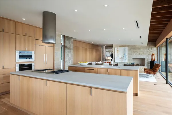 a large kitchen with stainless steel appliances a large counter top a stove and a refrigerator