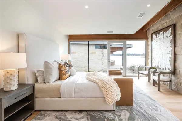 a bedroom with bed and large windows