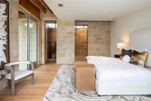 a spacious bedroom with a bed and glass door