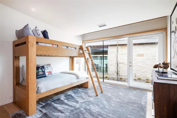 a bedroom with a bed and large windows