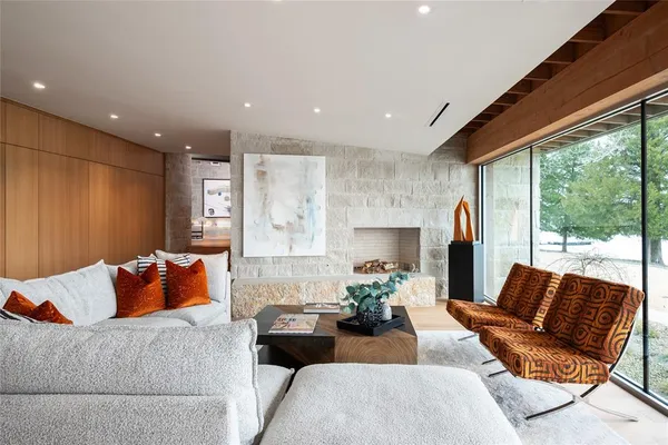 a living room with furniture fireplace and a large window