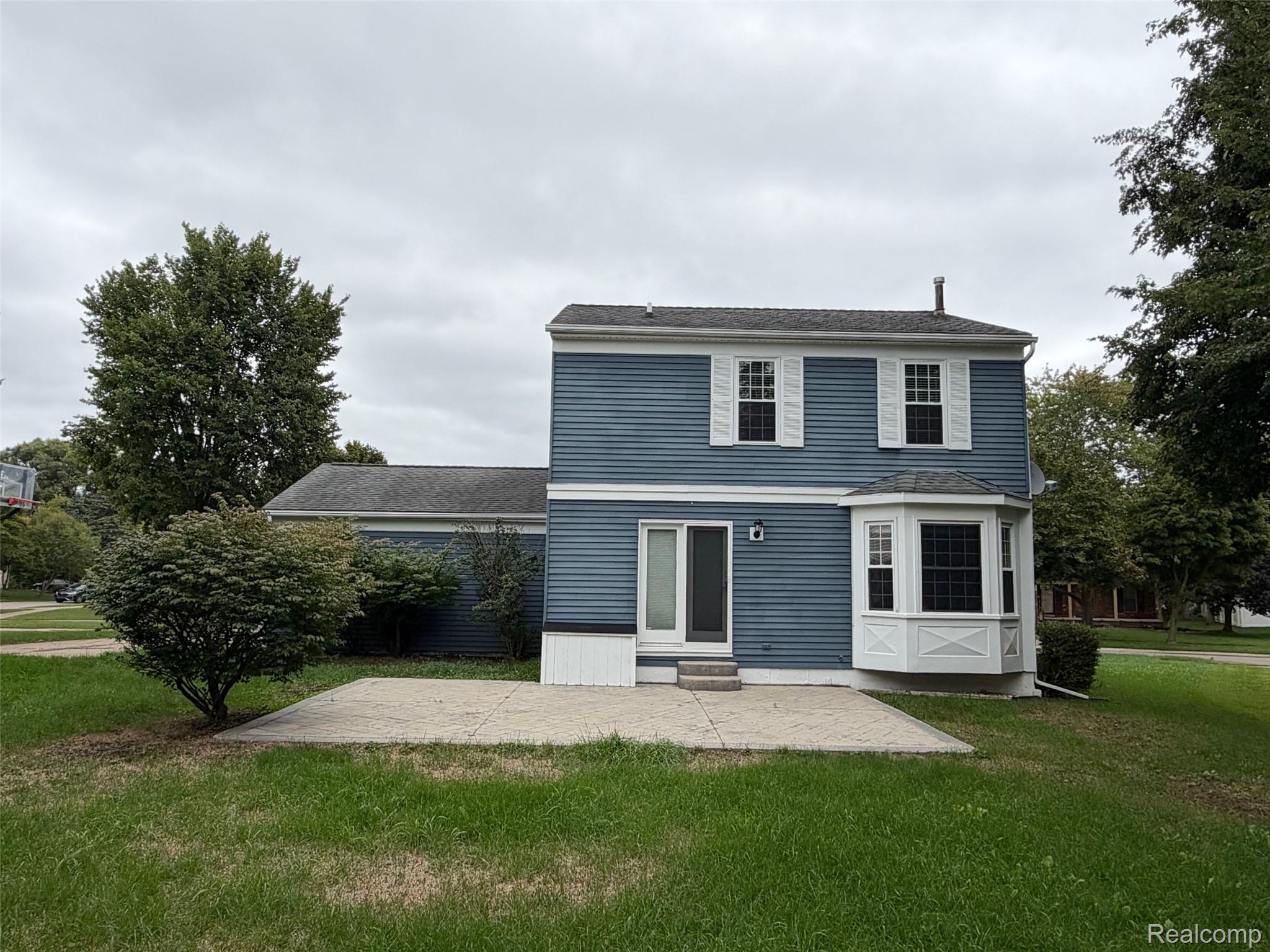 24525 Jamestowne Road Novi, MI 48375 - Photo 2 of 20 Blue siding exterior with white trim, bay window, sliding glass door, and an exterior patio