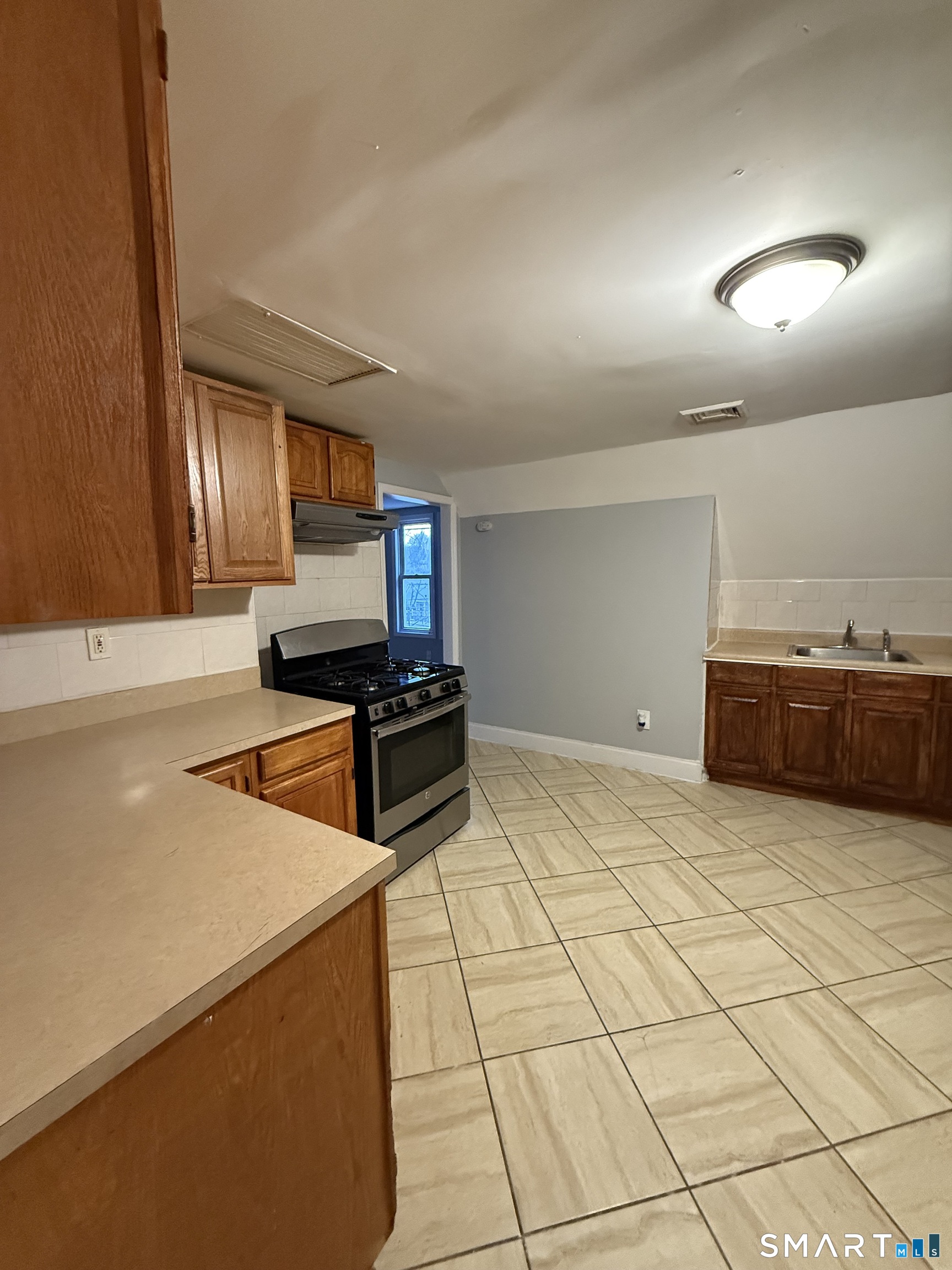 21 North Walnut Street, Unit 3 Waterbury, CT 06704 - Photo 4 of 8 a kitchen with stainless steel appliances a sink and a counter top space