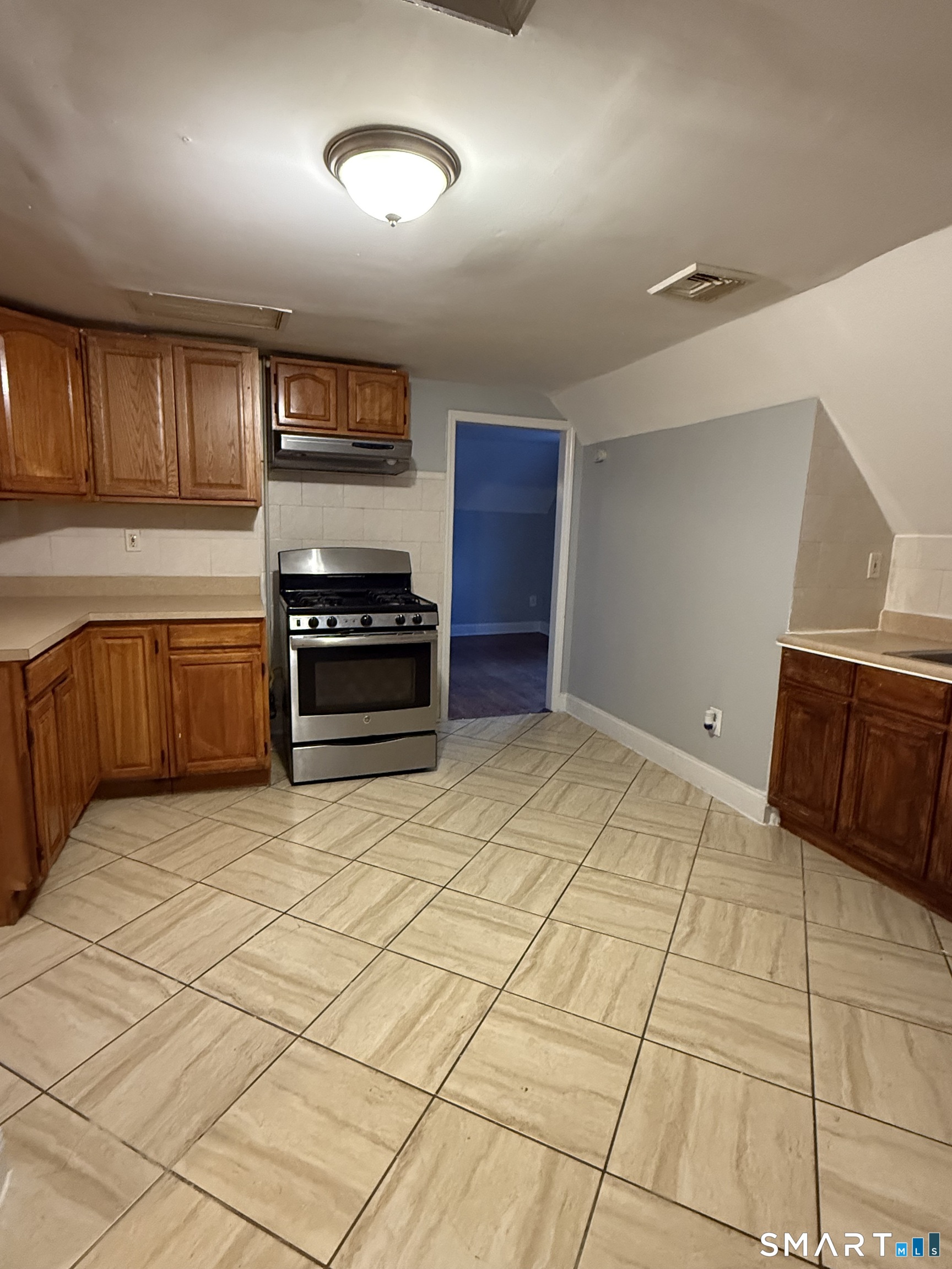 21 North Walnut Street, Unit 3 Waterbury, CT 06704 - Photo 7 of 8 a kitchen with stainless steel appliances granite countertop a refrigerator and a sink