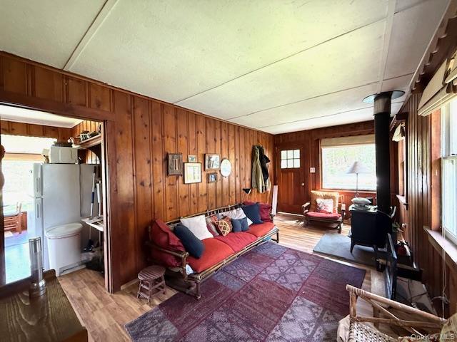 94 Airport Road Eldred, NY 12732 - Photo 12 of 18 flooring, a wood stove, and wooden walls